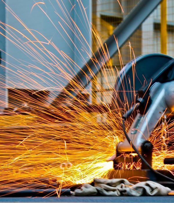 Un obrero cortando acero en una construcción